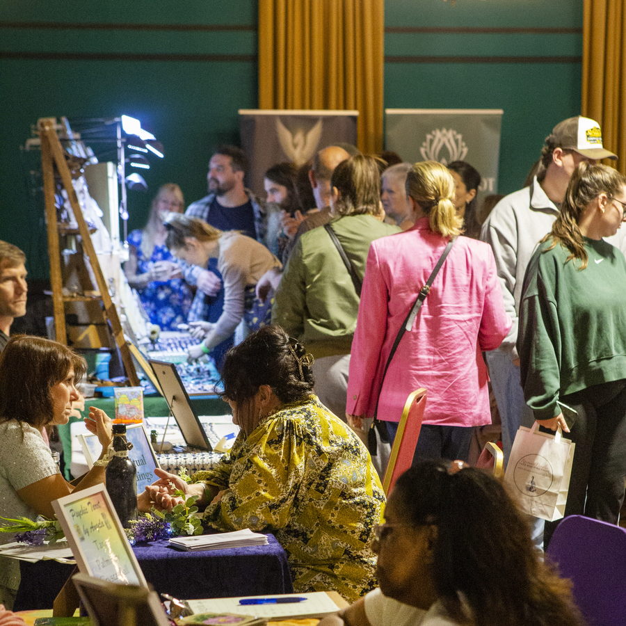 Visitors browsing exhibitor stalls in the main hall